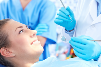 Dentist and dental assistant working on a woman's teeth